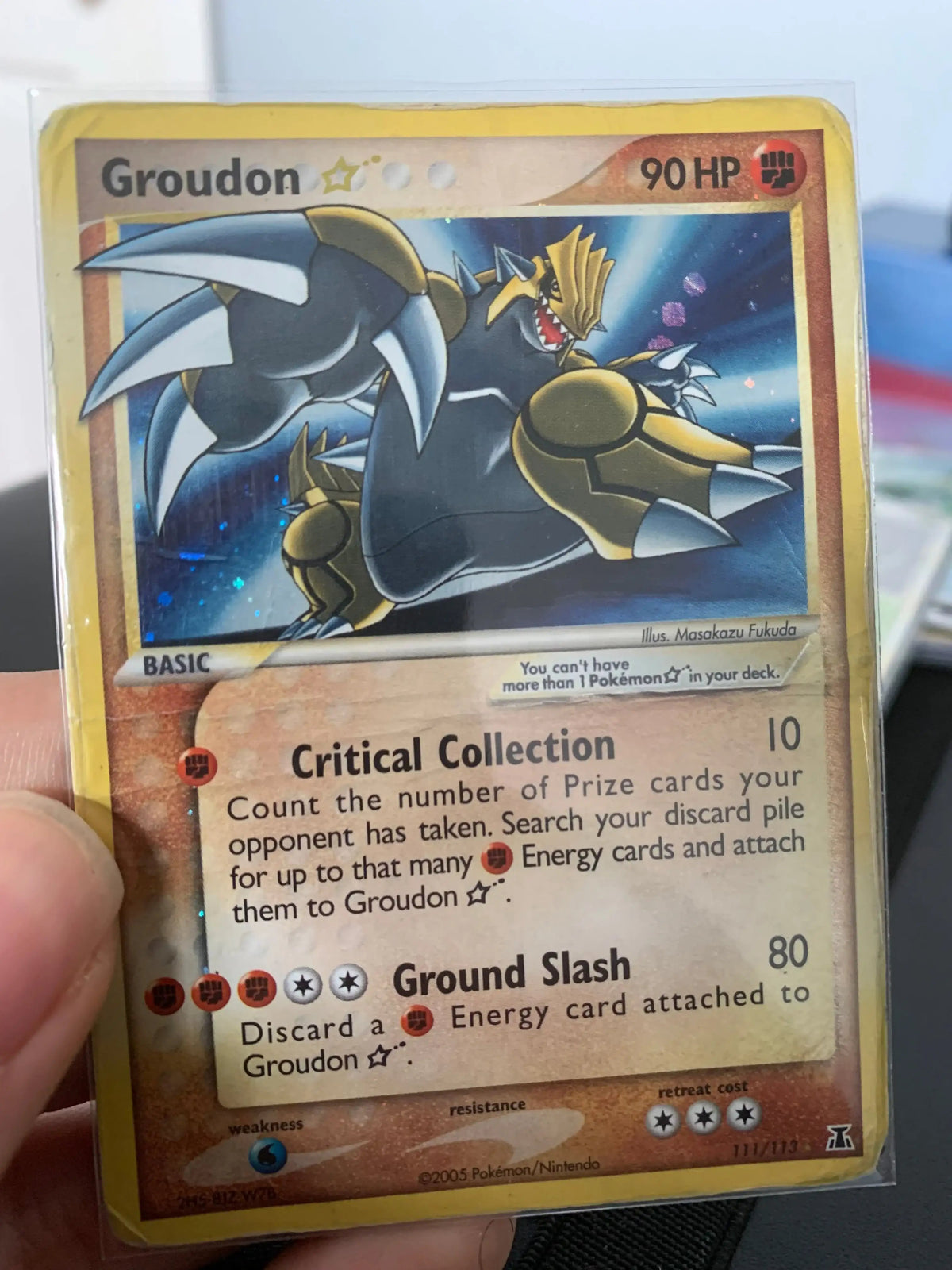 Groudon Star Pokémon trading card in protective sleeve, held by hand, collectible item