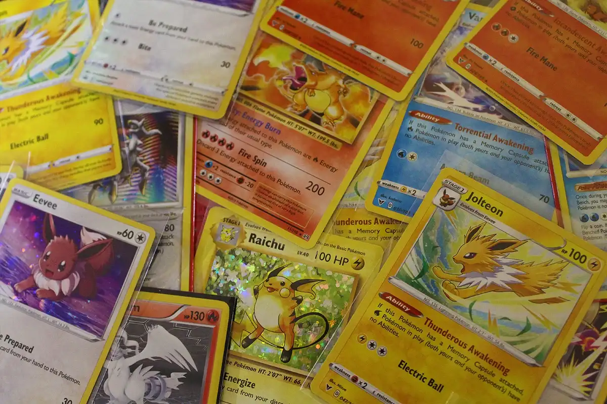 Assorted Pokémon trading cards including Eevee, Jolteon, Raichu, and Charizard