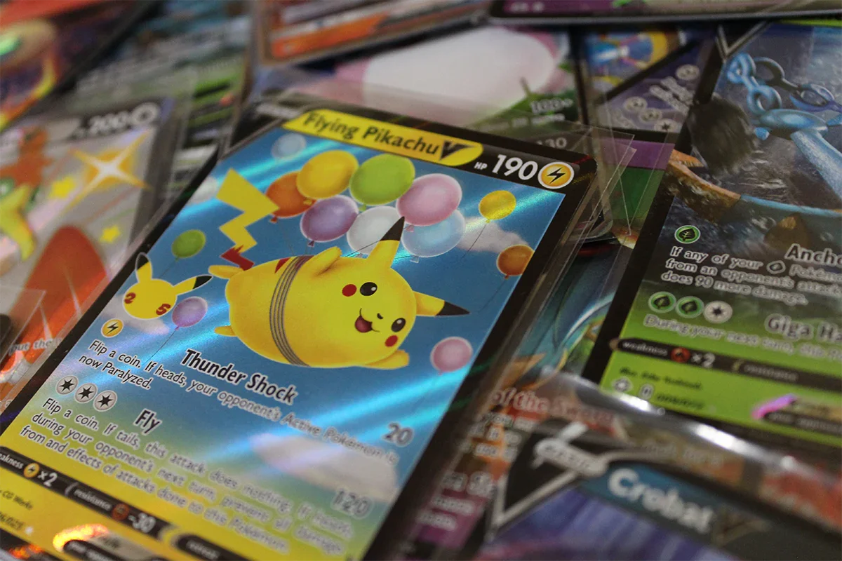 Close-up of Pokémon trading cards, featuring Flying Pikachu V, at PTC Collectibles online shop