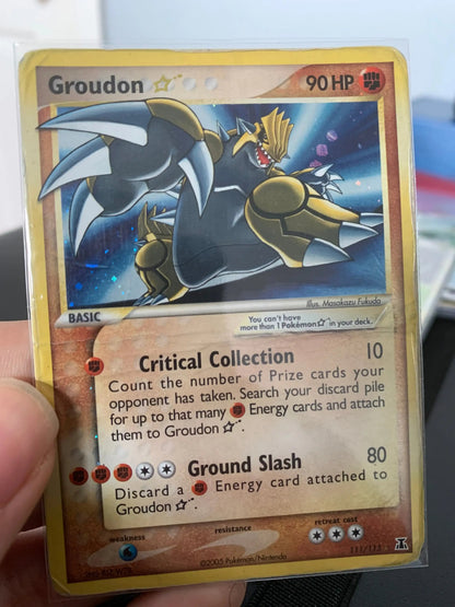 Groudon Star Pokémon trading card in protective sleeve, held by hand, collectible item
