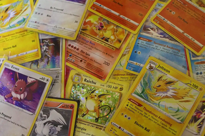 Assorted Pokémon trading cards including Eevee, Jolteon, Raichu, and Charizard